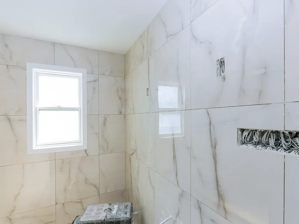 Alicatado de baño con azulejos grandes en Castellón